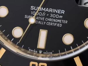 Close-up of the black dial of the Submariner Date Yellow Gold watch, showing gold markers, text 1000ft = 300m water.