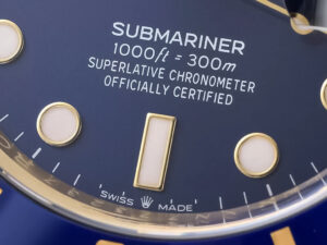 Close-up of the blue dial of the Submariner Date Yellow Gold (40mm) gold accents and "1000ft=300m" water resistance marking.