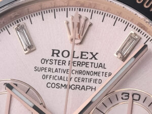 Close-up view of the pink dial of the Cosmograph Daytona Rose Gold Oysterflex, showcasing intricate details and branding.
