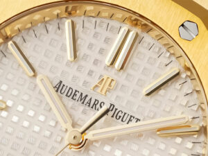 Close-up of the Royal Oak Yellow Gold watch with a silver dial featuring gold hour markers and the Audemars Piguet logo.