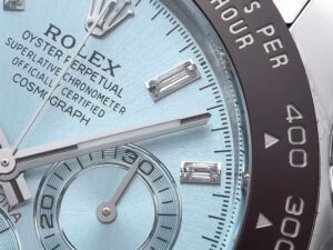 Close-up of the Cosmograph Daytona Platinum watch featuring an ice-blue diamond dial and black ceramic bezel with tachymeter.