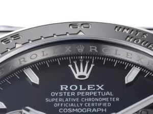 Close-up of the Cosmograph Daytona Stainless Steel (2023) black dial, showcasing branding and bezel engraving details.
