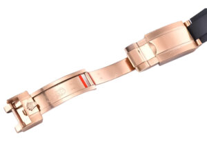Close-up of the rose gold clasp and black Oysterflex strap of the Cosmograph Daytona Rose Gold with Ivory Dial watch.