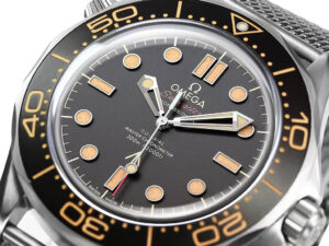 Close-up of the Seamaster Diver 300 Titanium ‘No Time to Die’ (42mm) watch face with a black dial and vintage-style indices.