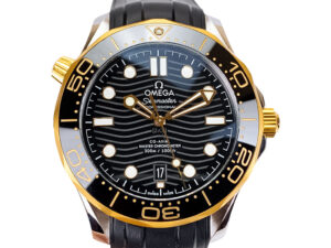 Seamaster Diver 300, 42mm stainless steel watch with black dial, gold bezel, and rubber strap shown in close-up view.