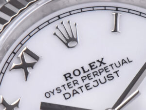 Close-up of the Datejust 36 watch with a white dial, Roman numerals, fluted bezel, and Jubilee bracelet.