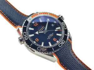 Seamaster Planet Ocean 600 with blue dial, orange accents, and rubber strap (43.5mm) displayed at an angled view.