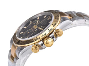 Two-tone yellow gold and steel Cosmograph Daytona watch with a black dial, showcasing its bezel and chronograph pushers.