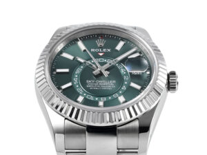 Sky-Dweller Stainless Steel watch with green dial, fluted bezel, and Oyster bracelet displayed on a product page.