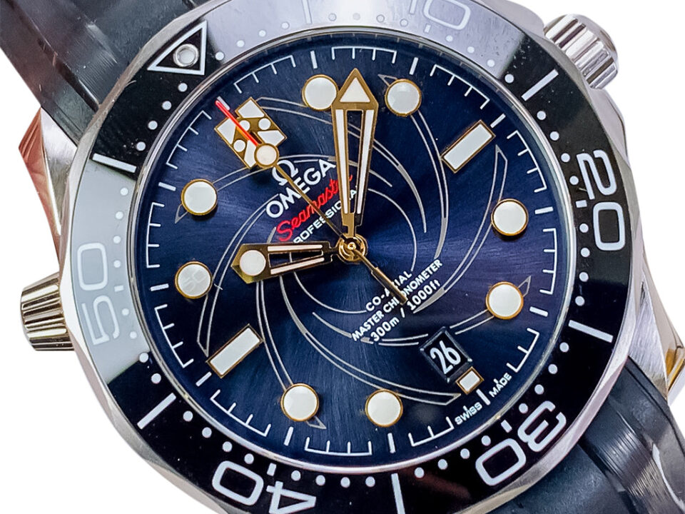 Close-up of the Seamaster Diver 300 ‘James Bond’ watch on strap, featuring blue dial with a spiral pattern and gold accents.