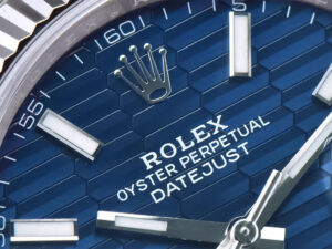 Close-up of the blue fluted motif dial of the Datejust 41, showcasing stainless steel hands markers with fluted bezel detail.