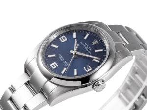 Oyster Perpetual 36 Stainless Steel watch with blue dial, Arabic numerals, and a polished metal bracelet, angled side view.