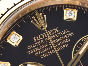 Close-up of the Cosmograph Daytona Yellow Gold Diamond Black Dial, showcasing gold accents and diamond hour markers.