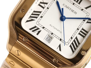 Close-up of Santos Large Yellow Gold watch (40mm) featuring a white dial, blue sword-shaped hands, Roman numeral markers.