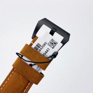 Close-up of the brown strap and black buckle of the Luminor 1950 3 Days GMT Automatic Ceramica with tag attached.