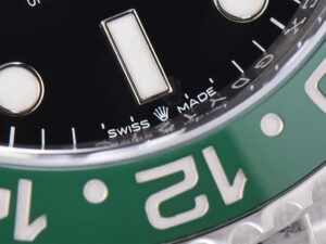 Close-up view of the green and black bezel, Swiss-made marking, and dial on the GMT-Master II Stainless Steel ‘Sprite’.