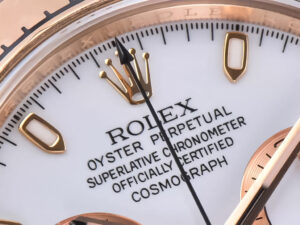 Close-up view of the Cosmograph Daytona Rose Gold with Ivory Dial, showcasing its design and gold crown logo detail.