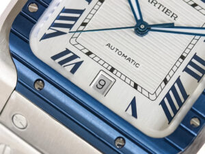 Close-up view of Santos Large Stainless Steel Watch with white dial, blue bezel, Roman numerals, date display at 6 o’clock.