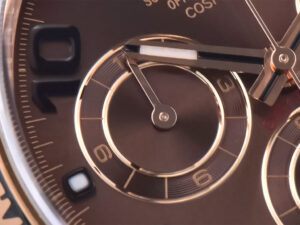 Close-up of the Cosmograph Daytona Rose Gold watch face with chocolate dial, Arabic numerals, detailed chronograph subdials.