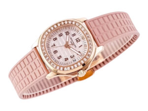 Rose gold watch with diamond bezel, pink textured strap, and a white dial displaying black numerals. Aquanaut Luce model.
