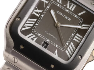 Close-up of Santos Large Stainless Steel watch with grey dial, grey bezel, Roman numerals, automatic movement, date display.