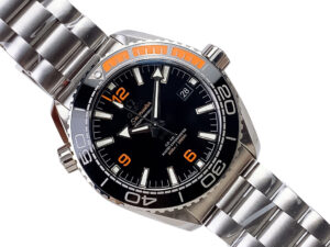 Seamaster Planet Ocean 600 with Black Dial featuring a stainless steel bracelet, orange accents, date display at 3 o'clock.