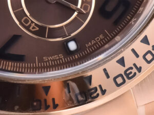 Close-up of the Cosmograph Daytona Rose Gold watch featuring a chocolate dial, Arabic numerals, and "Swiss Made" inscription.