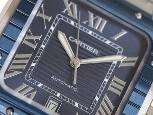 Close-up of Santos Large Stainless Steel watch with blue dial, blue bezel, Roman numerals, and date display at 6 o'clock.
