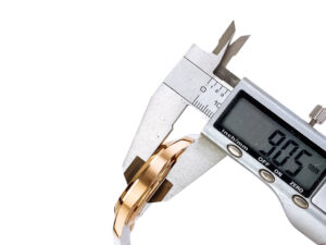 Digital caliper measuring the thickness of the Aquanaut Rose Gold with Chocolate Dial and White Strap (40mm) wristwatch.
