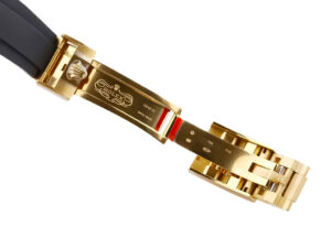 Close-up of the yellow gold clasp with engraved Rolex logo on the Cosmograph Daytona Yellow Gold Oysterflex watch.