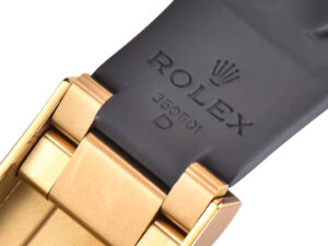 Close-up of the clasp on Cosmograph Daytona Yellow Gold Oysterflex with Black and Champagne Dial, featuring engraving.