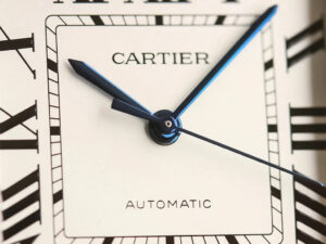 Close-up of the Santos Large Two Tone Yellow Gold (40mm) with white dial, blue sword-shaped hands, Roman numeral markers.
