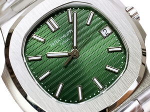 Close-up of the Nautilus Stainless Steel watch with a green textured dial, silver hour markers, & date display at 3 o'clock.