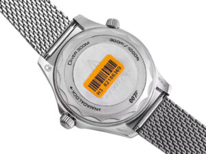 Back view of the Seamaster Diver 300 Titanium ‘No Time to Die’ (42mm), showing its case back details and metal mesh bracelet.