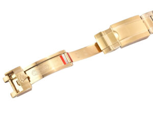 Yellow gold strap clasp of Cosmograph Daytona watch, showcasing engraved details and accents in polished finish.