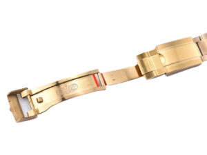 Close-up view of the yellow gold clasp and bracelet for the Cosmograph Daytona with intricate detailing.