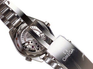 Close-up of the Seamaster Planet Ocean 600 watch, showcasing its black dial, stainless steel bracelet, and open case back.