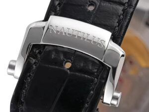 Close-up of the stainless steel clasp engraved with "Nautilus" on a black leather strap of the 40mm watch.