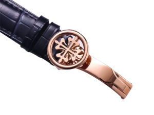 Rose gold clasp of the Celestial Only Watch with intricate design, attached to a black leather strap.