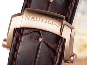 Close-up view of the rose gold clasp engraved with "NAUTILUS," attached to a brown leather strap of the 40mm watch.