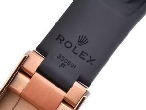 Close-up of the strap and clasp of the Cosmograph Daytona Rose Gold Oysterflex with engraved Rolex logo and model number.