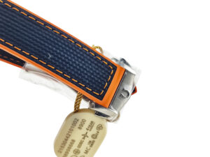 Close-up of the Seamaster Planet Ocean 600's blue rubber strap with orange stitching and stainless steel clasp, showing tag.