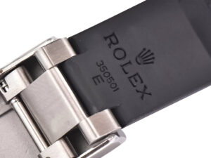 Close-up of the Cosmograph Daytona White Gold Oysterflex strap showing Rolex branding and metal clasp detail.