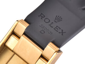 Close-up of the Cosmograph Daytona Yellow Gold Oysterflex strap showing the Rolex logo and clasp details in black and gold.