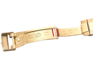 Close-up image of the clasp and inner part of the yellow gold Jubilee bracelet for GMT-Master II, showing engraved details.