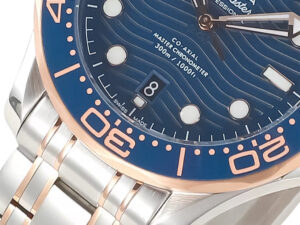 Close-up of the Seamaster Diver 300 Two Tone Rose Gold with Blue Dial (42mm), showcasing its wave pattern and date window.